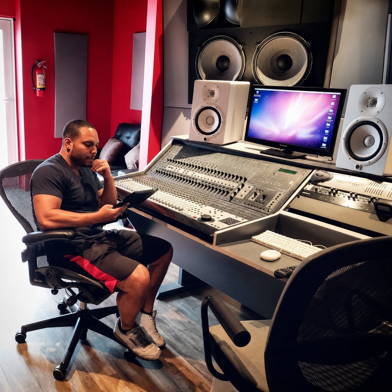 Abel J. Fernandez in a recording studio with speakers and a mixing console